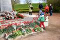 Жители Нарвы несут цветы к братской могиле.