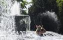 Женщина охлаждается в фонтане в Германии.