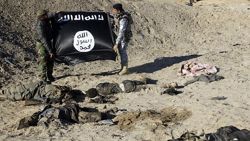 Iraagi julgeolekujõudude sõdurid demonstreerivad 23. detsembril 2014 Ramadi linna lähedal Islamiriigi lippu