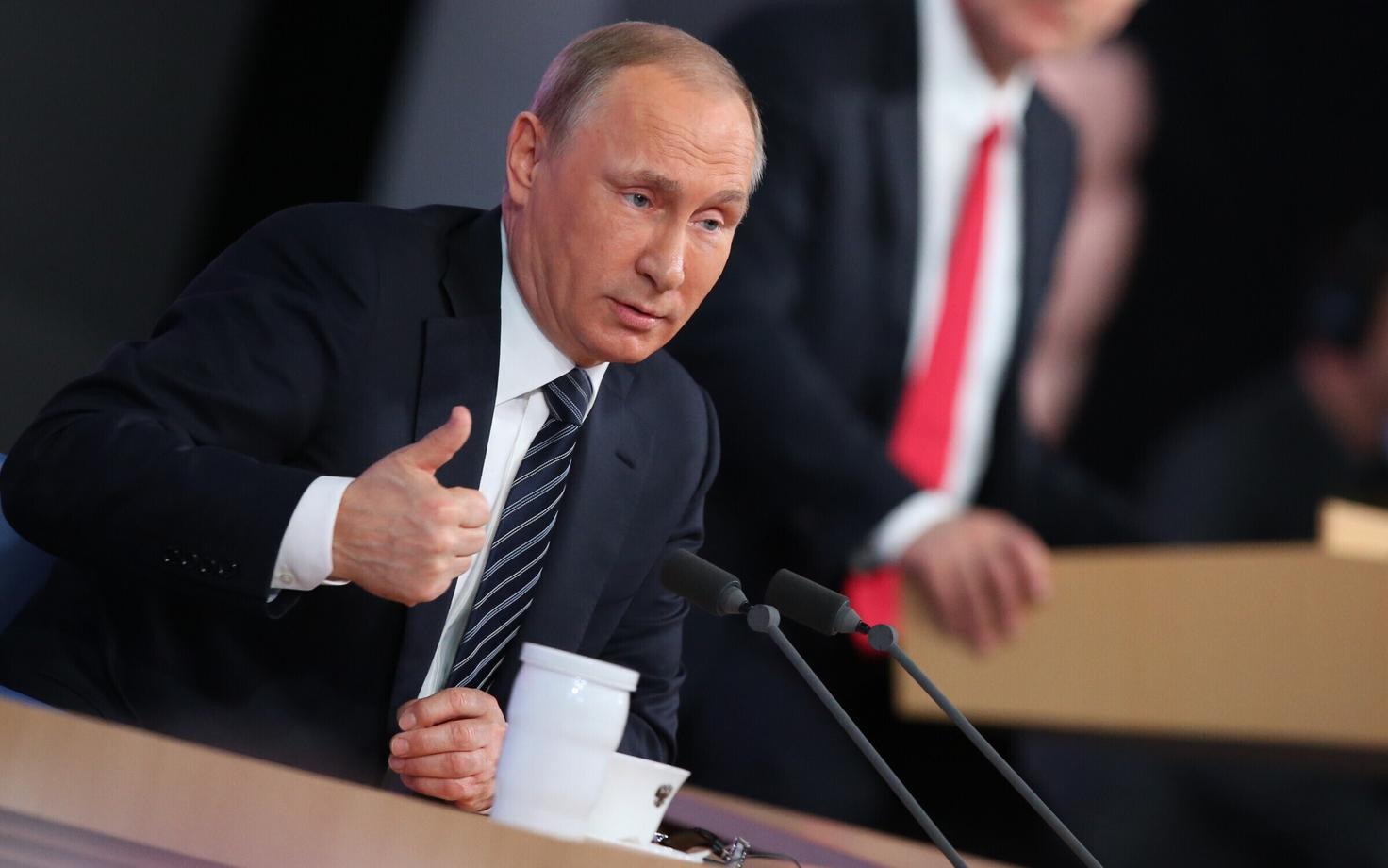Vladimir Putin ja taustal Dmitri Peskov