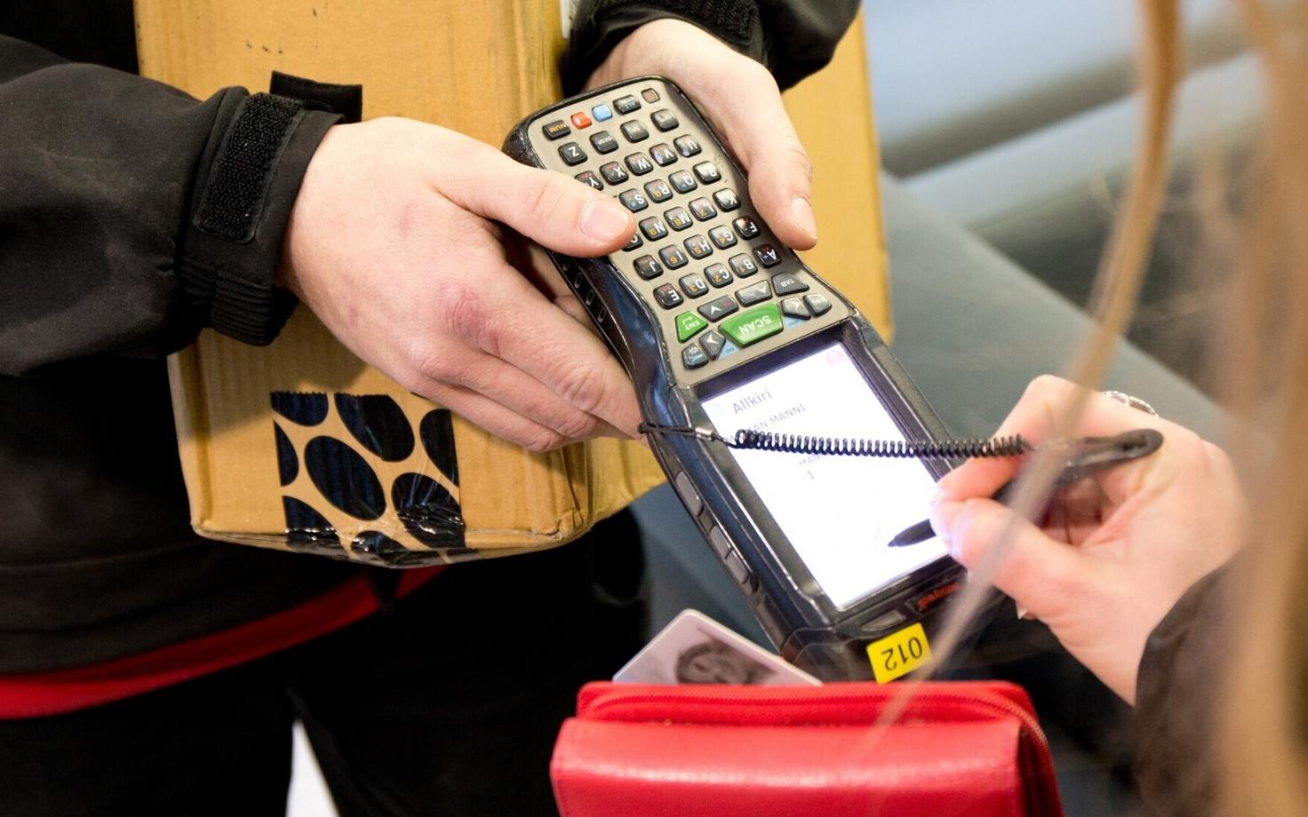 A customer signs for the delivery of an online purchase.