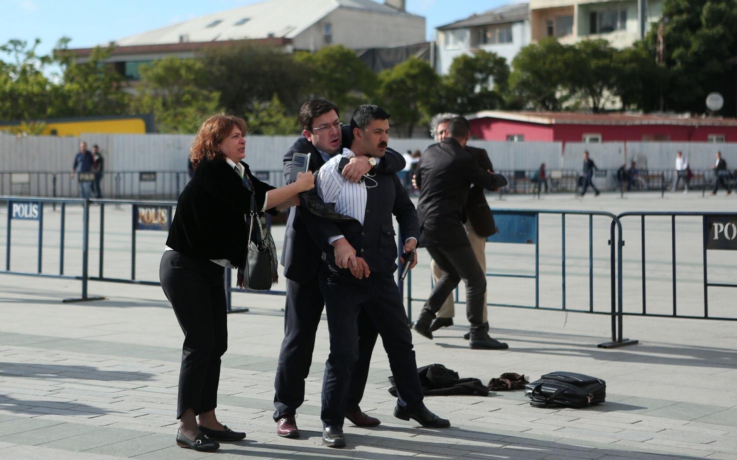 Can Dundari abikaasa Dilek Dundar proovis peatada relvastatud kahtlusalust (paremal), kes lasi Istanbuli kohtu eest opositsioonilise ajakirjaniku suunas kolm lasku.