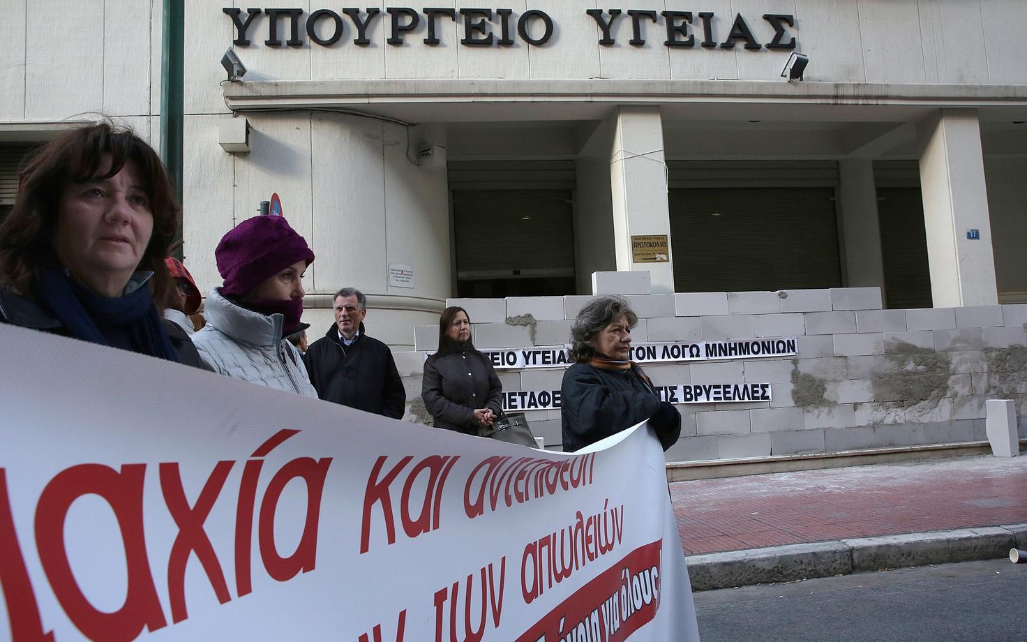 Kreeka meditsiinitöötajad meeleavalduse käigus kinni müüritud sissepääsuga tervishouministeeriumi ees kärbete vastu protestimas.