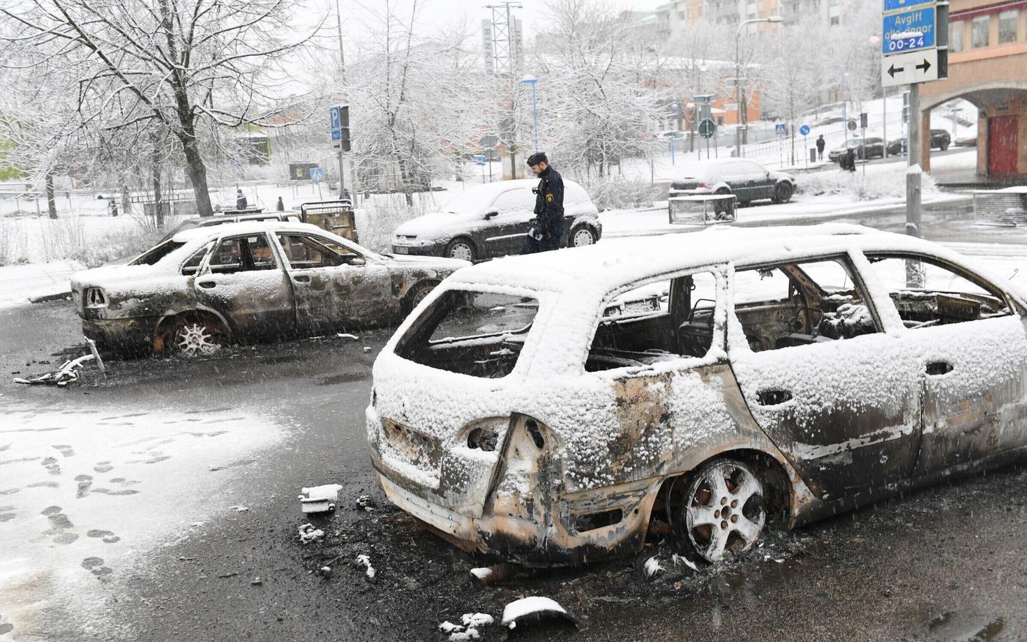 Rootsi politseinik 21. veebruaril Rinkeby linnaosas põlenud autosid vaatamas.