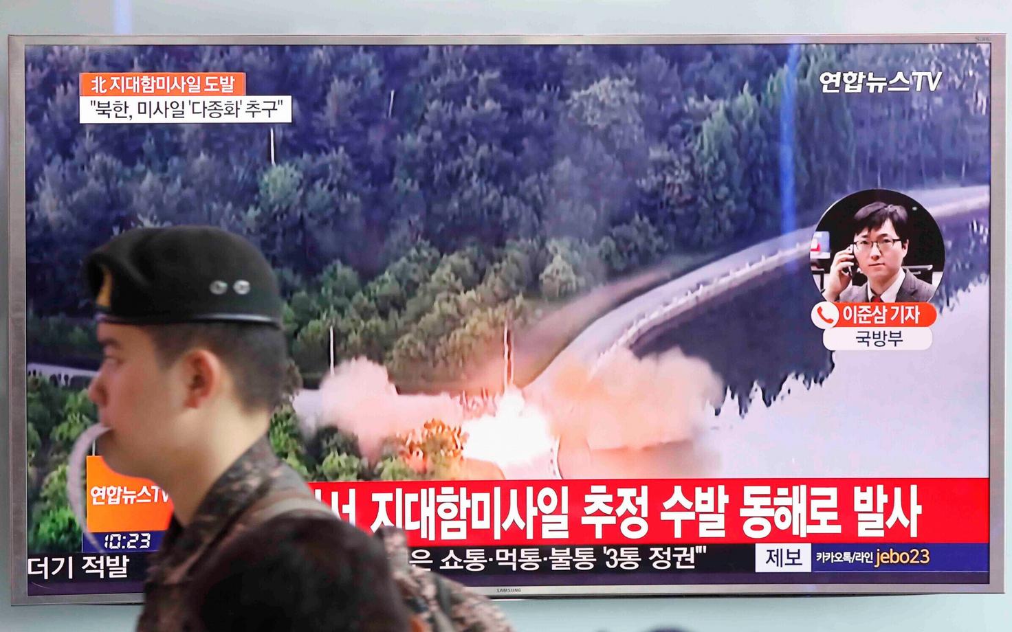 Lõuna-Korea sõdur avaliku teleekraani ees raudteejaamas.