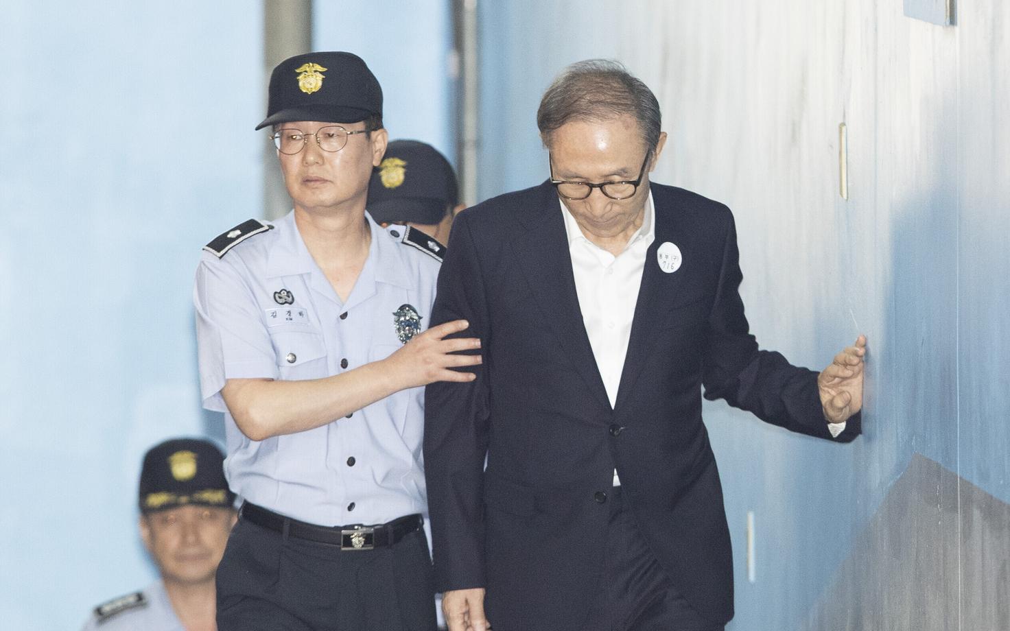 Lee Myung-bak (paremal) teel kohtuotsust kuulama