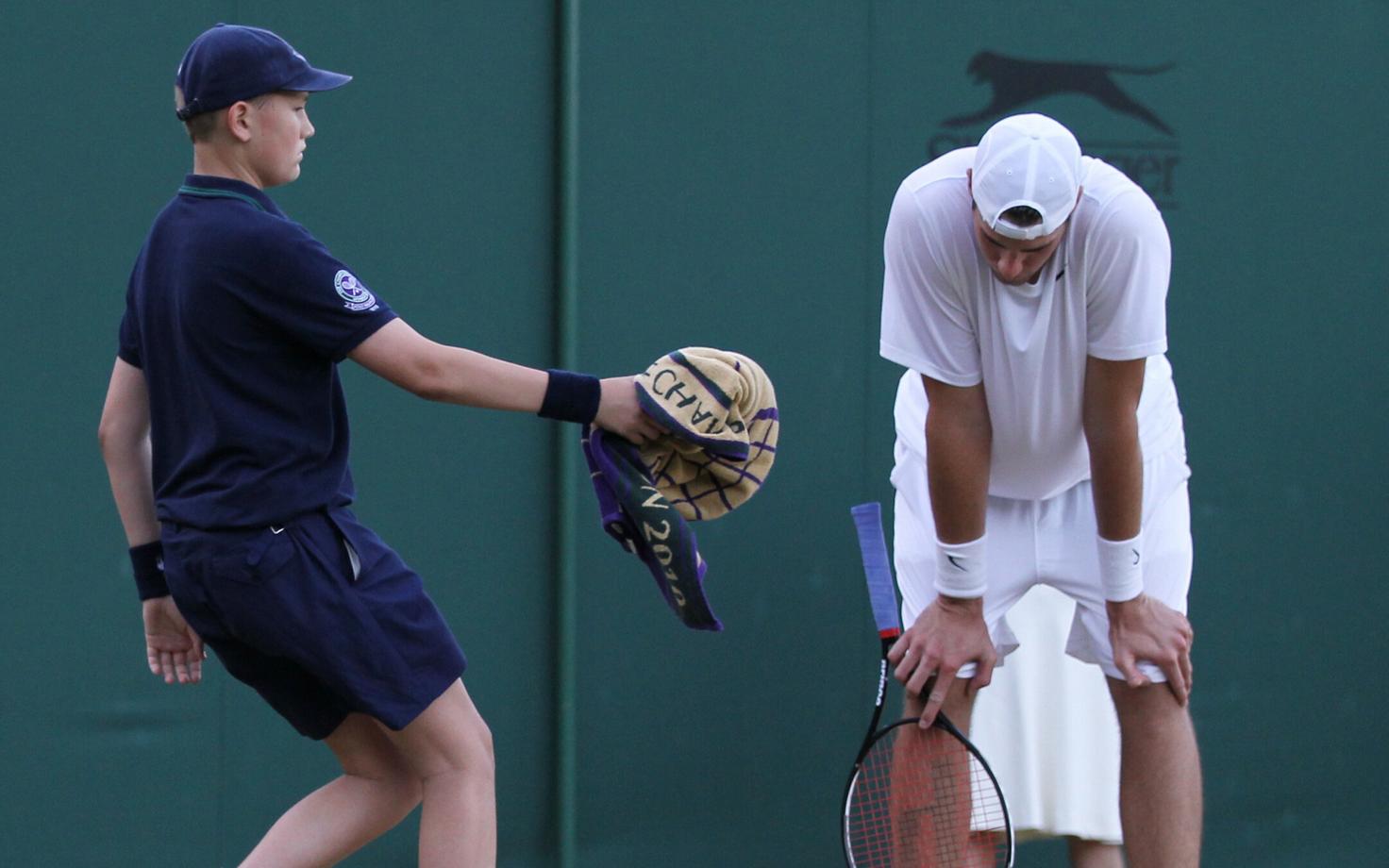 Pallipoiss Wimbledonis John Isnerile rätikut ulatamas.