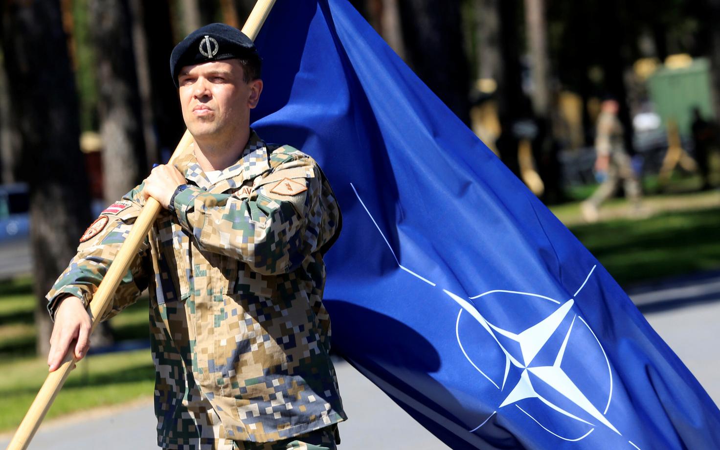 Латвийский солдат с флагом НАТО.