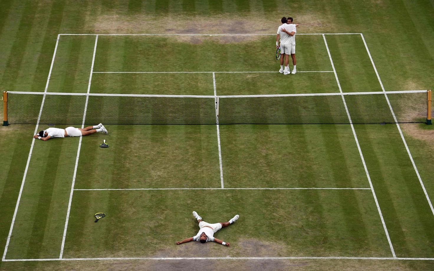 Juan Sebastian Cabal ja Robert Farah on võitjatena murule langenud, teisel pool võrku kallistavad Nicolas Mahut ja Edouard Roger-Vasselin.