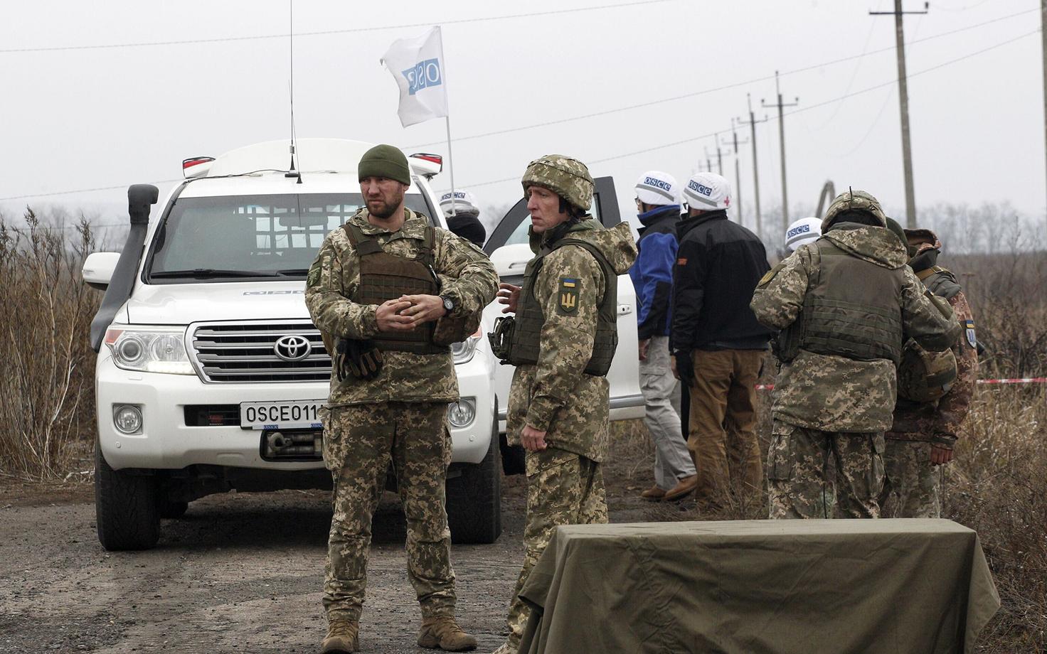 OSCE vaatlejad Bogdanivka küla juures vastaspoole lahkuviimist jälgimas.