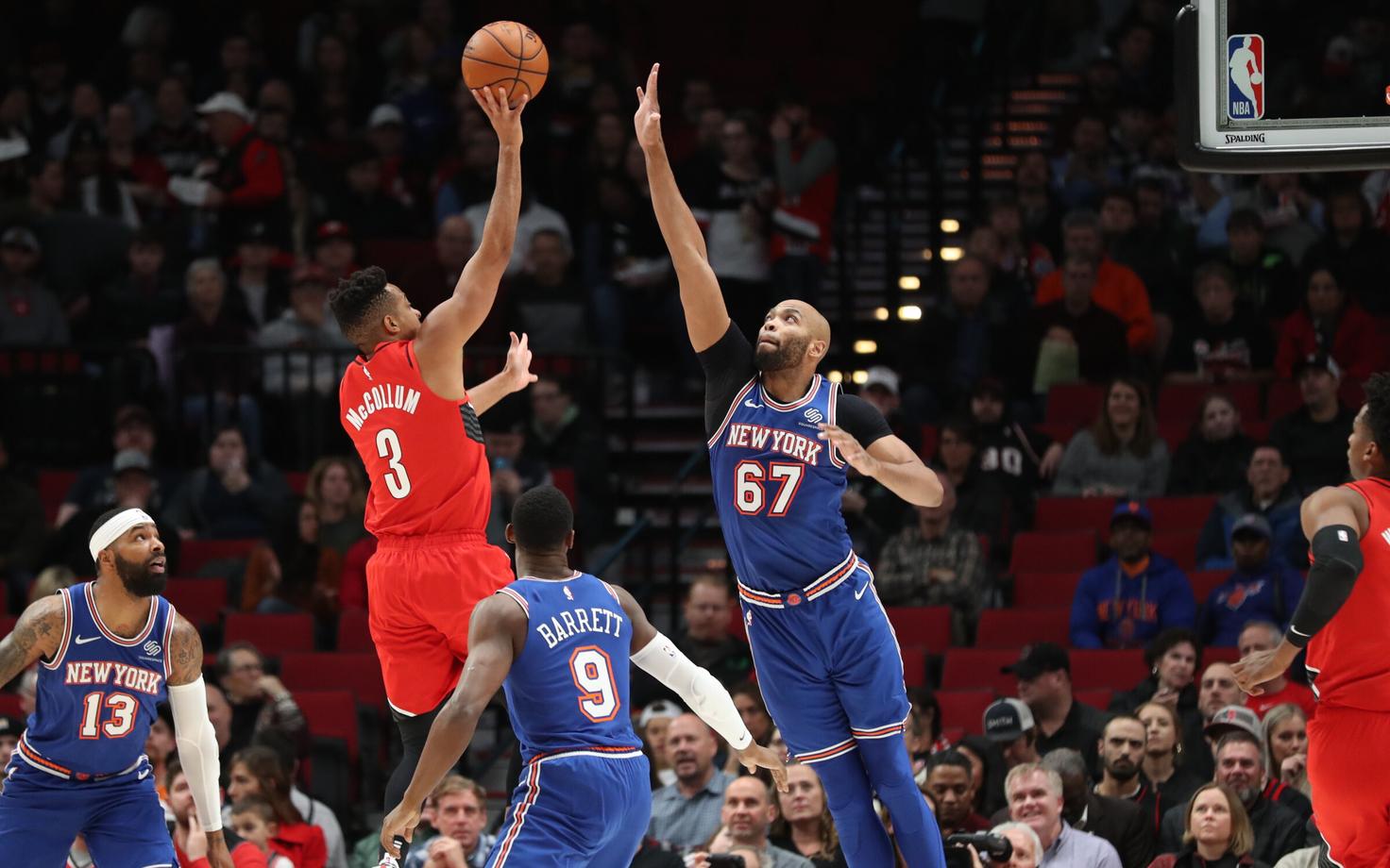 CJ McCollum saadab palli üle Knicksi mängija korvi.