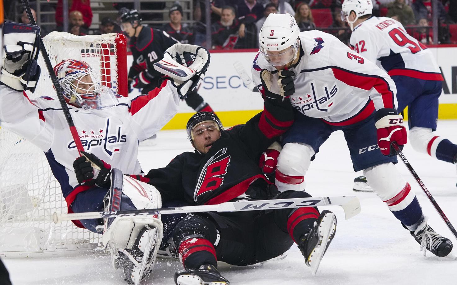 Carolina Hurricanes mängija Nino Niederreiter (keskel) koos Washington Capitalsi väravavahi Ilja Samsonovi (vasakul) ja kaitsemängija Nick Jenseniga (3)