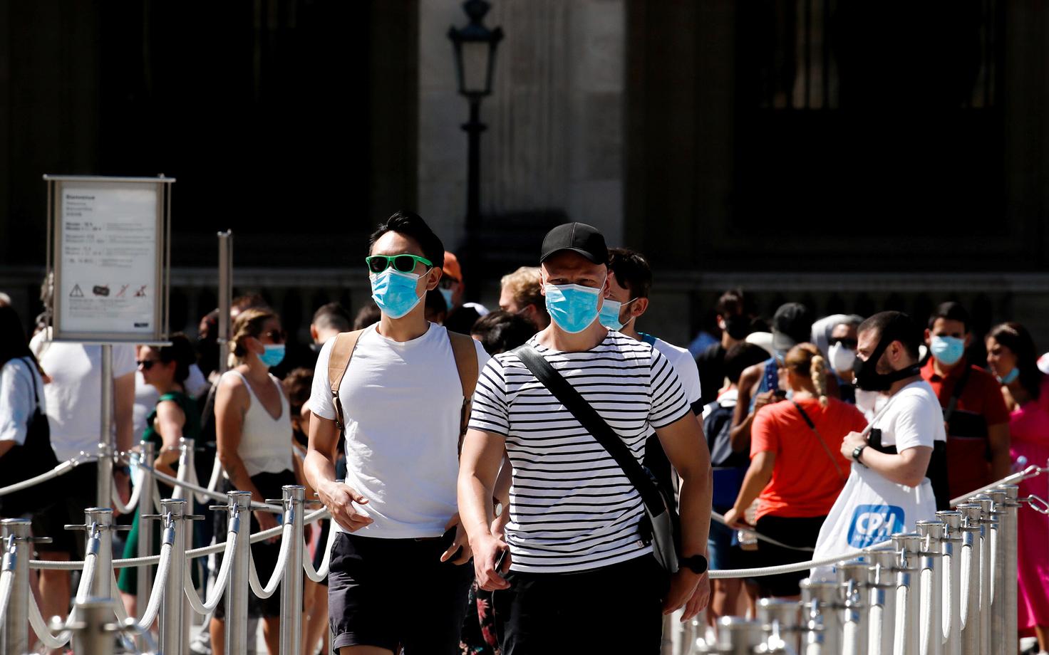 Maske kandvad inimesed Pariisis Louvre'i juures.