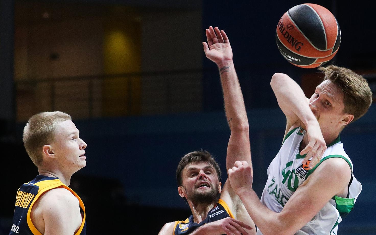 Himki mängijad piiramas Marius Grigonist.