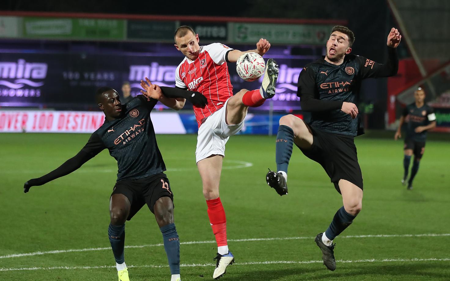 Will Boyle võitlemas palli eest Manchester City mängijate Benjamin Mendy ja Aymeric Laporte'iga