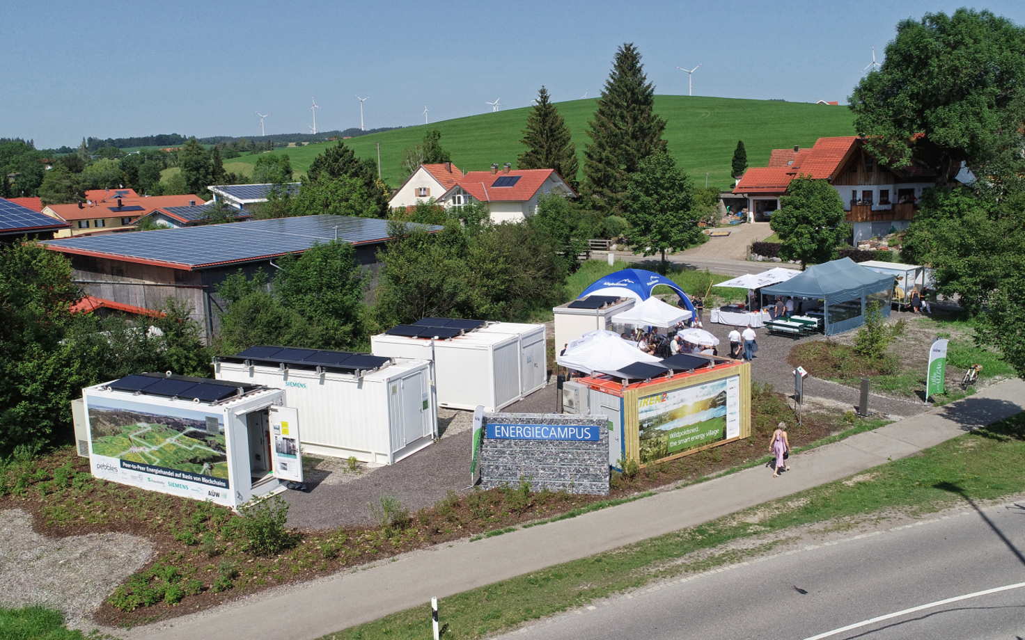 Joonis 1. Droonivaade mikrovõrgule (Vasakult-paremale: energiasalvesti, kahesuunaline muundur, lülituskeskus, trafoalajaam. Ees: juhtimiskeskus)