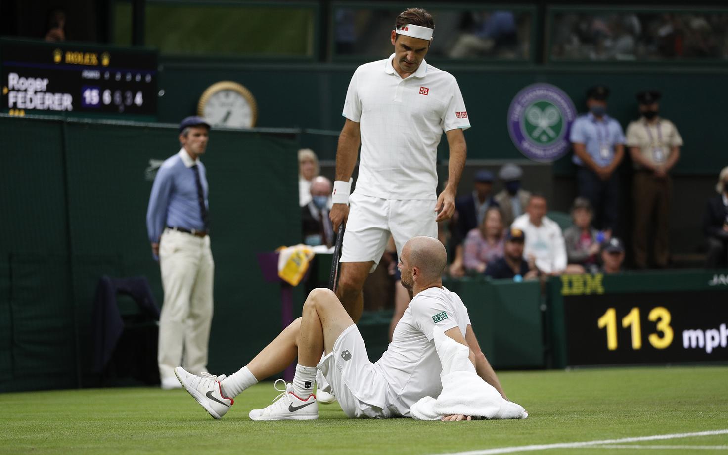 Roger Federer (püsti) lohutamas libastuse tõttu vigastada saanud Adrian Mannarinot.