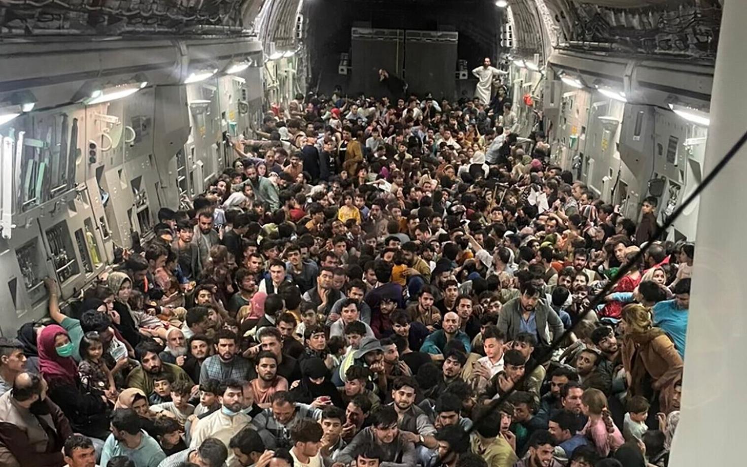 Inimesed istuvad Kabulist lahkuva USA transpordilennuki C-17 põrandal.