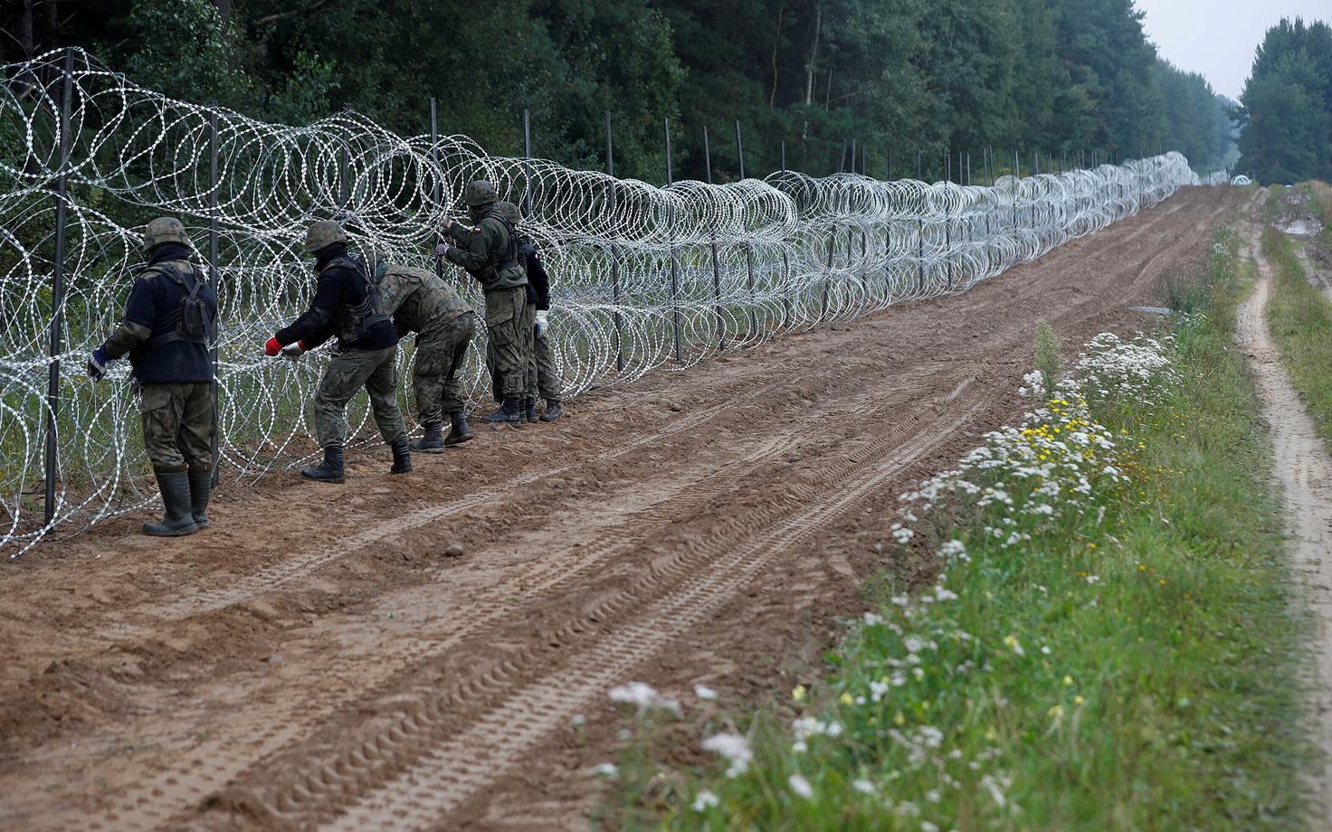 Poola piriivalvurid Nomiki küla lähistel piiril Valgevenega ajutist piiritõket paigaldamas.