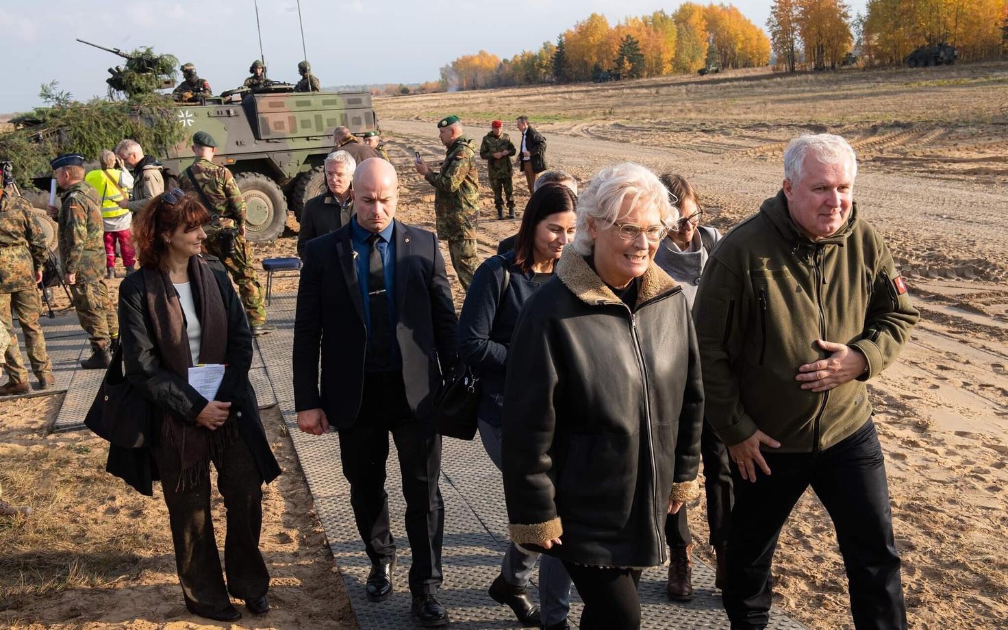 Saksa ja Leedu kaitseministrid koos saatjaskonnaga Leedus, taustal Saksa soomuk