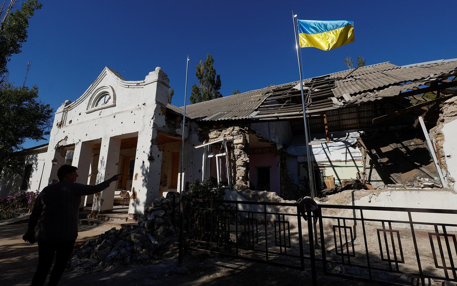 Украинский флаг перед администрацией города Лиман Николаевской области, пострадавшей в результате российского обстрела.