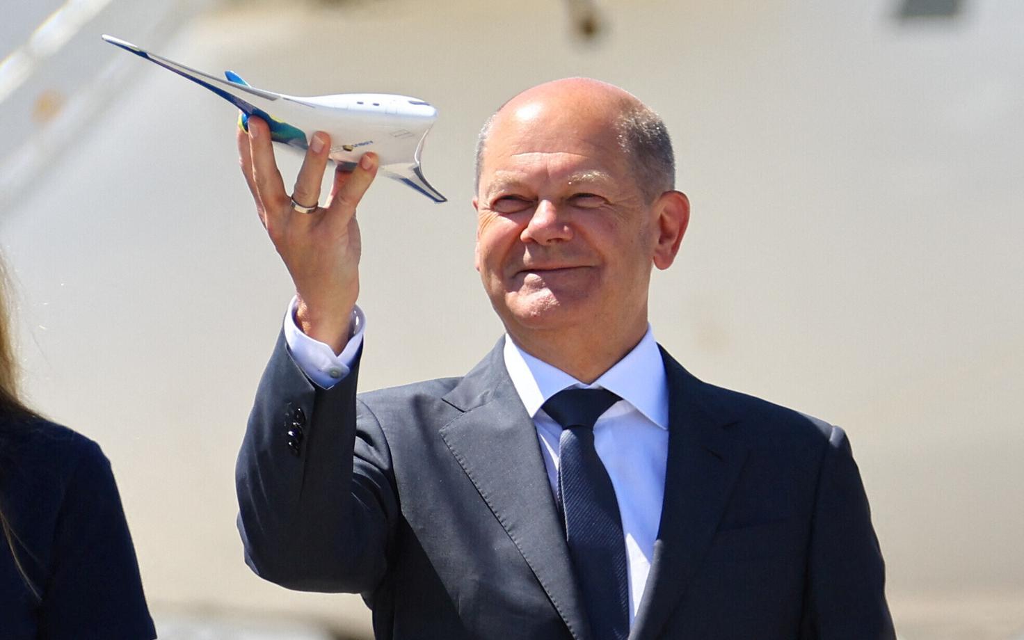 Канцлер Германии Олаф Шольц с моделью самолета Airbus на авиавыставке в Берлине.