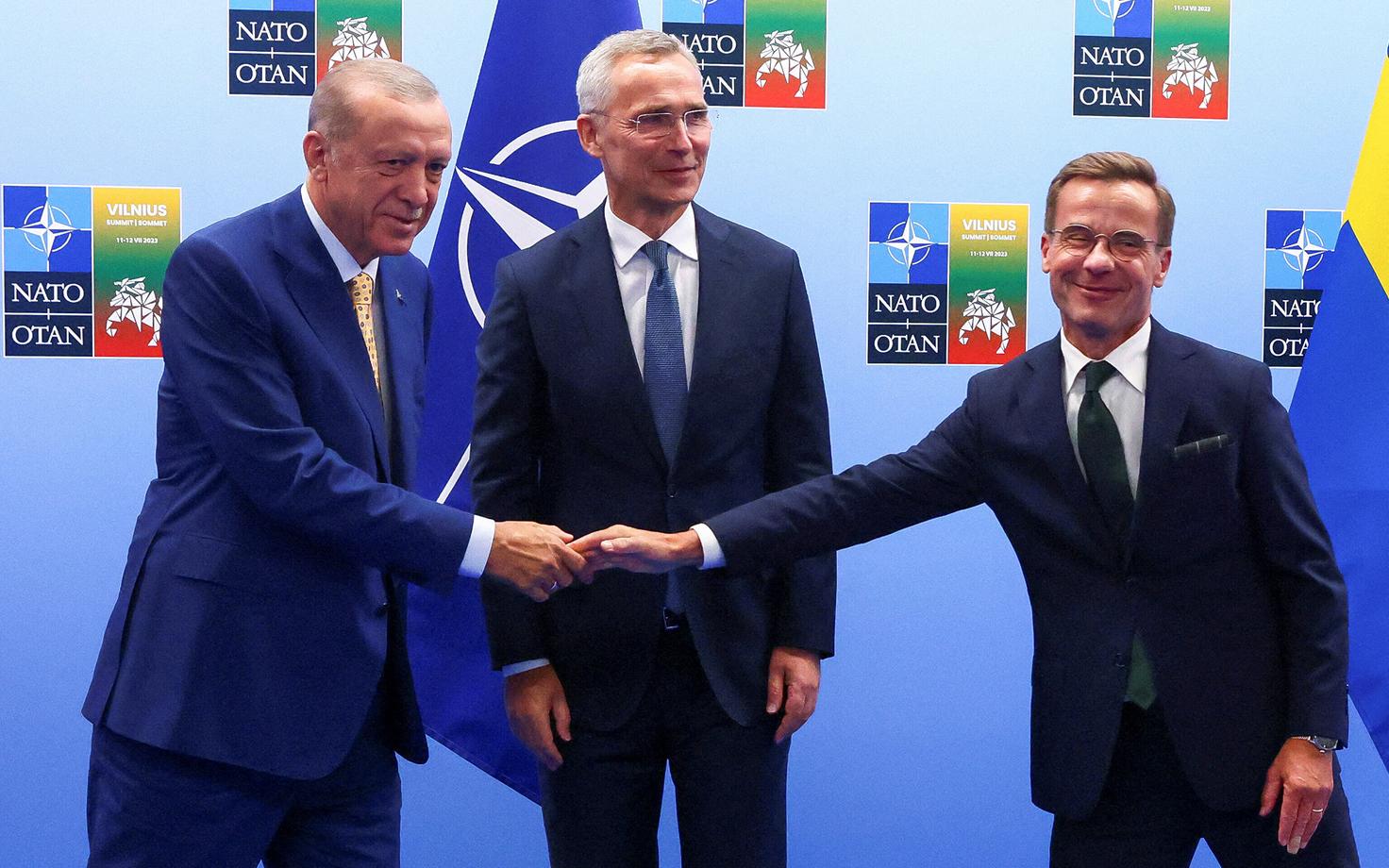 Türgi president Recep Tayyip Erdogan (vasakul) ja Rootsi peaminister Ulf Kristersson tervitavad teineteist NATO peasekretäri Jens Stoltenberg ees Vilniuse tippkohtumisel.