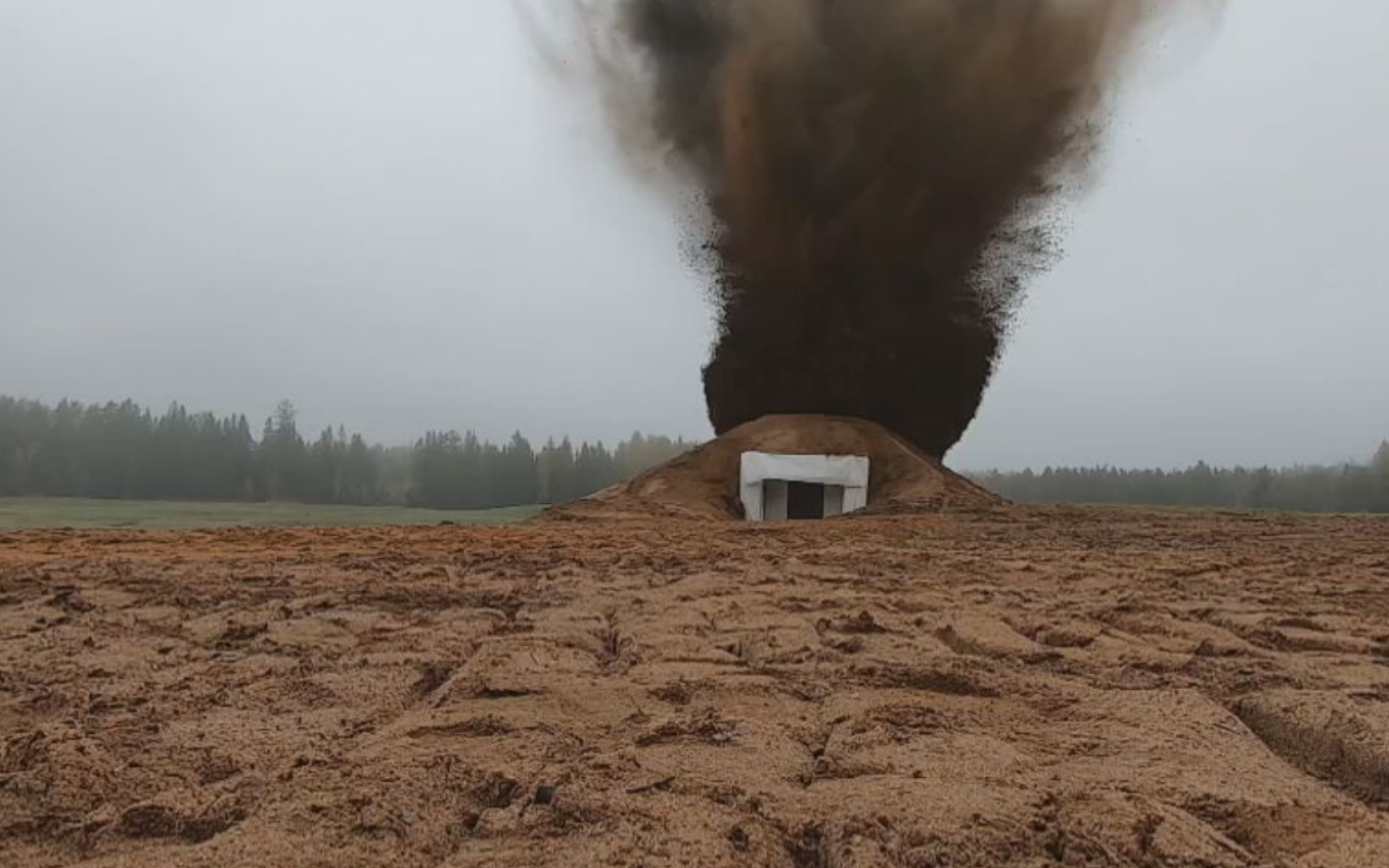 One of the prototype concrete bunkers being subjected to a blast test, via artillery fire.