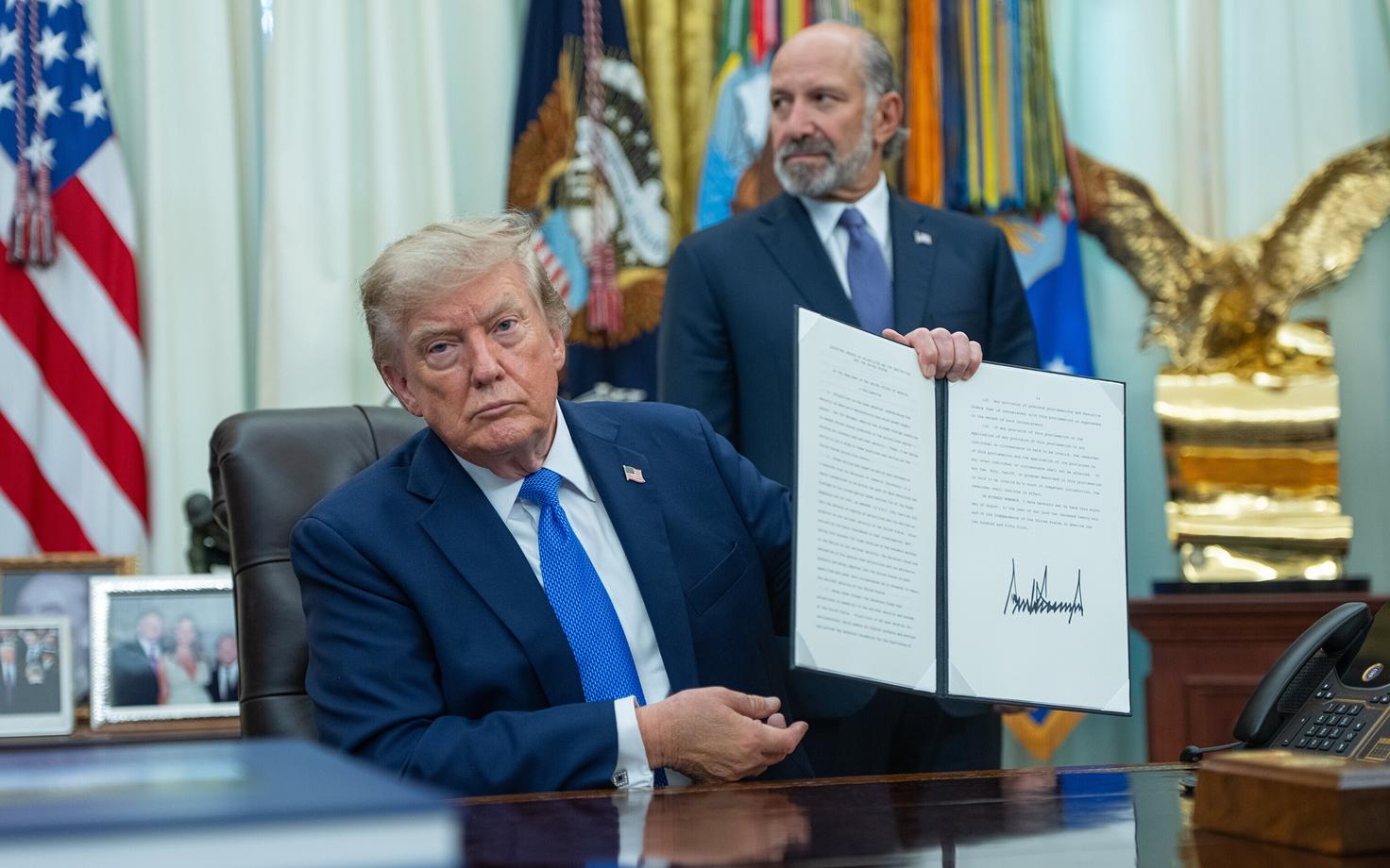 Дональд Трамп демонстрирует подписанный президентский указ.