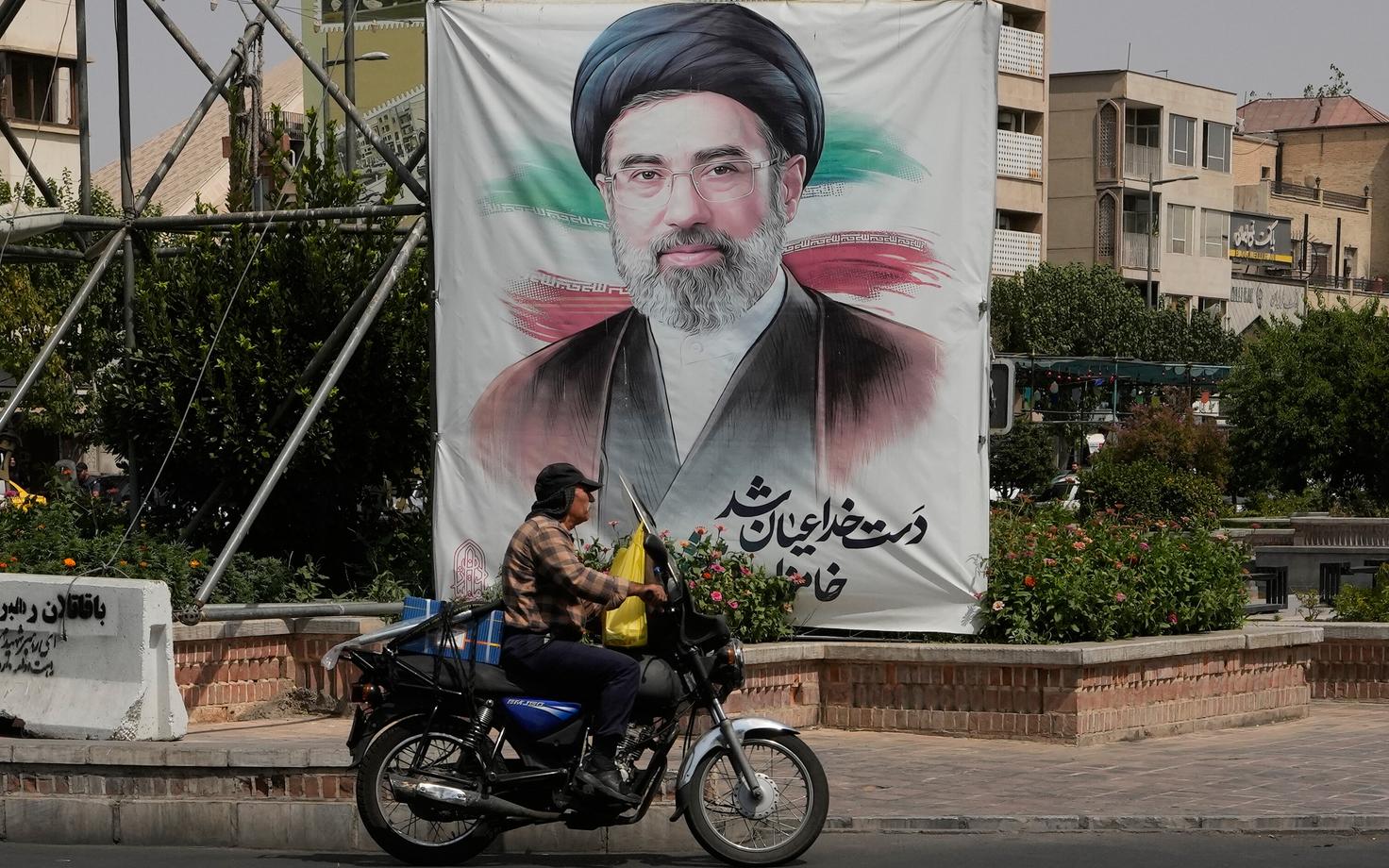 Mees sõidab mööda Iraani kõrgeima juhi ajatolla Mojtaba Khamenei plakatist