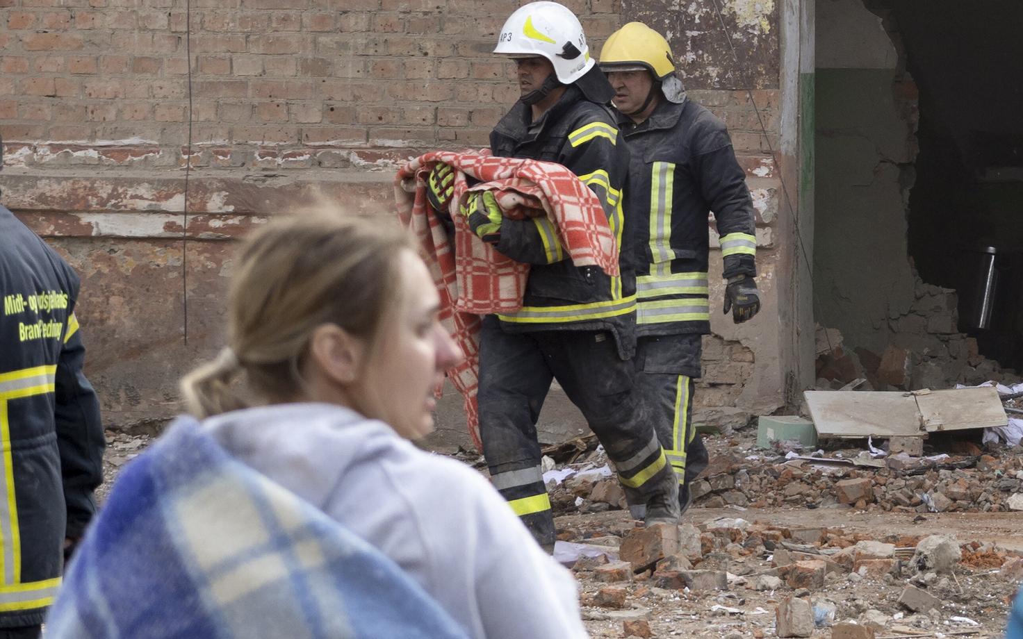 Ukraina tuletõrjuja toob Prõlukõs tabamuse saanud hoonest välja imiku surnukeha.