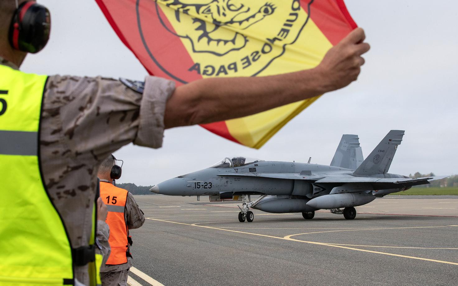 A flag with the Wing 15 patch and the Spanish national colors as the pilots make ready to leave.
