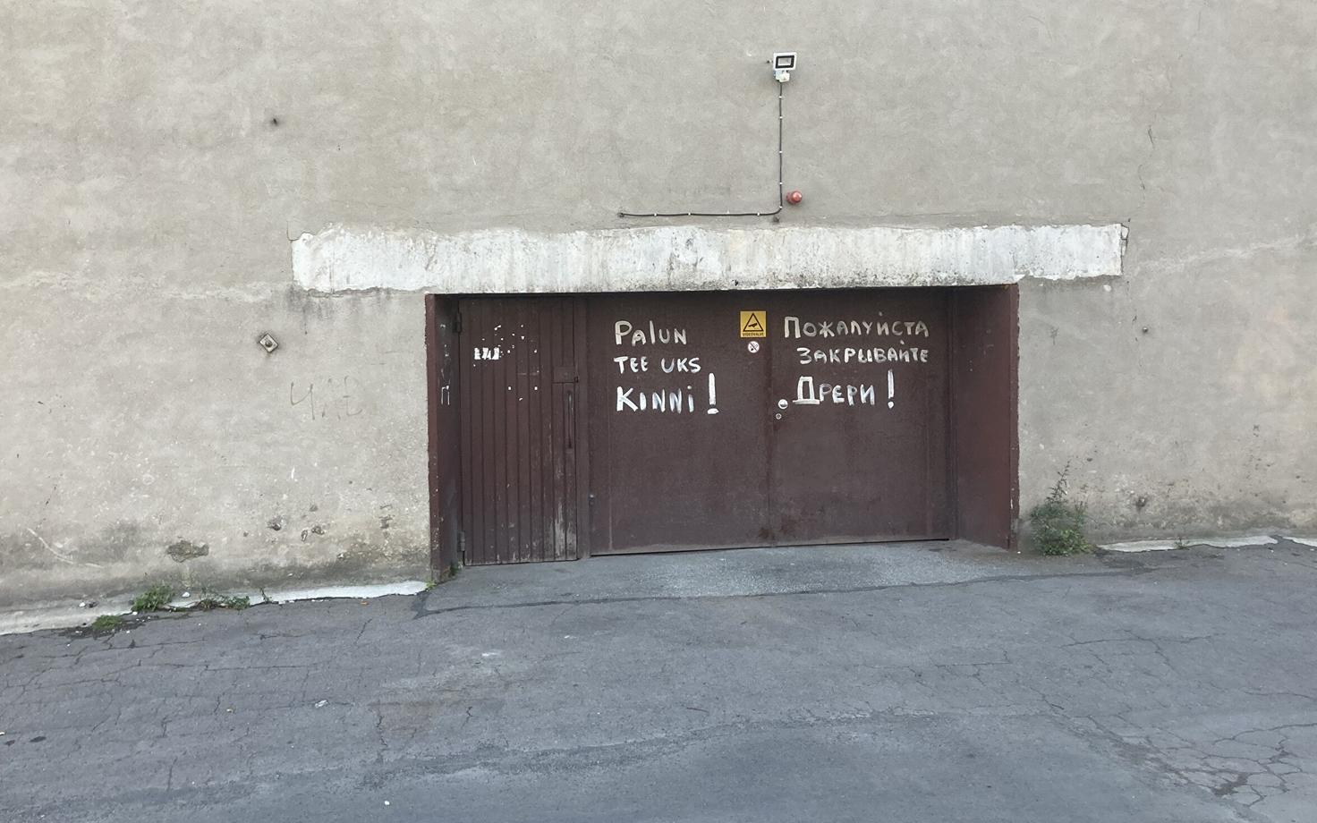 Message painted on a door in Russian (right) and unclear Estonian (left).
