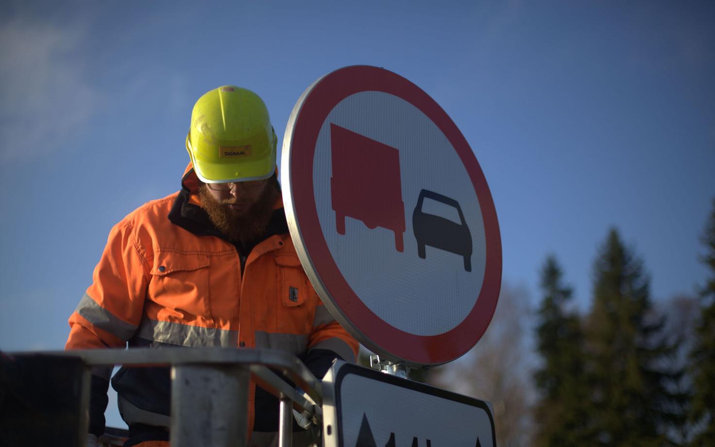 Signs prohibiting trucks from overtaking being installed.